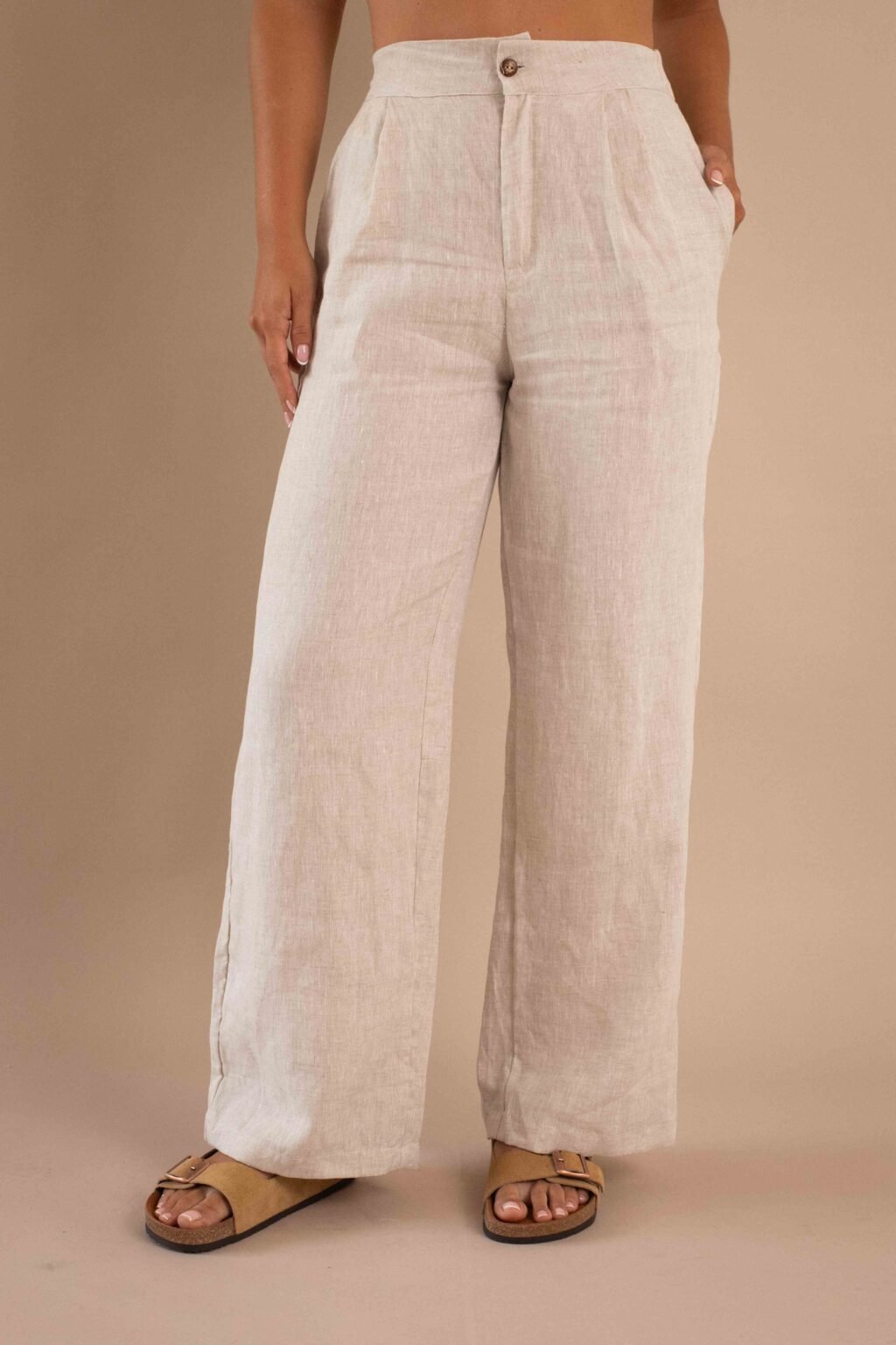 Modelo vistiendo el Pantalón Serenidad de lino para mujer color natural con bota ancha.