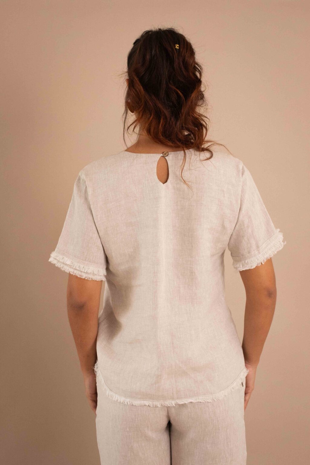 Top Serenidad de lino color crudo con drapeado ajustable y bordes deshilados.