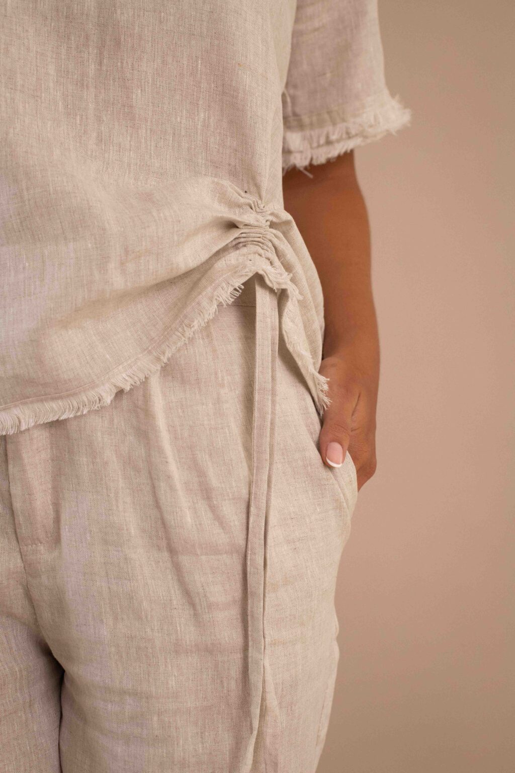 Top Serenidad de lino color crudo con drapeado ajustable y bordes deshilados.