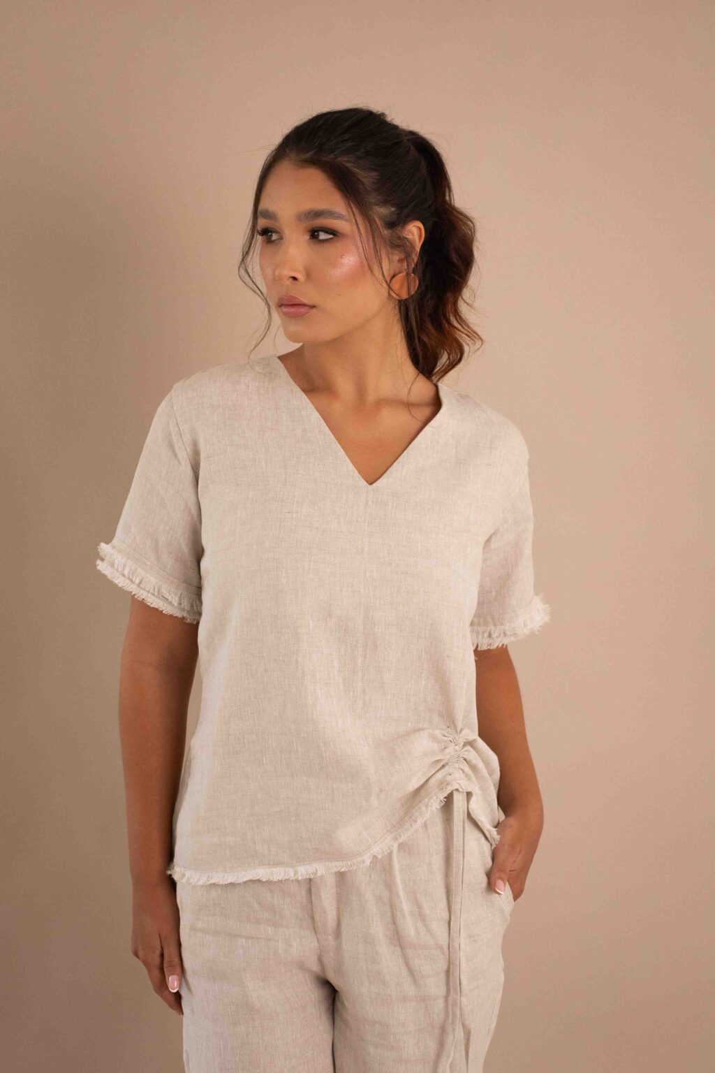 Top Serenidad de lino color crudo con drapeado ajustable y bordes deshilados.