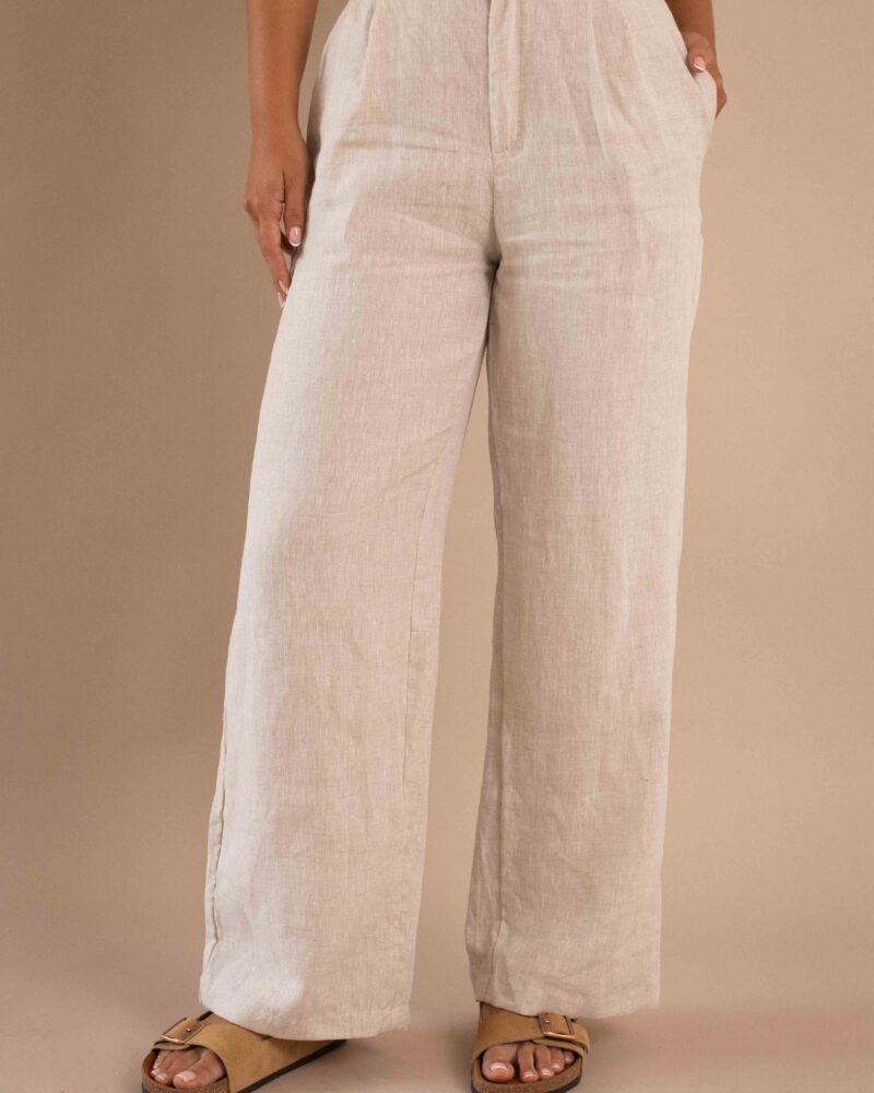 Modelo vistiendo el Pantalón Serenidad de lino para mujer color natural con bota ancha.