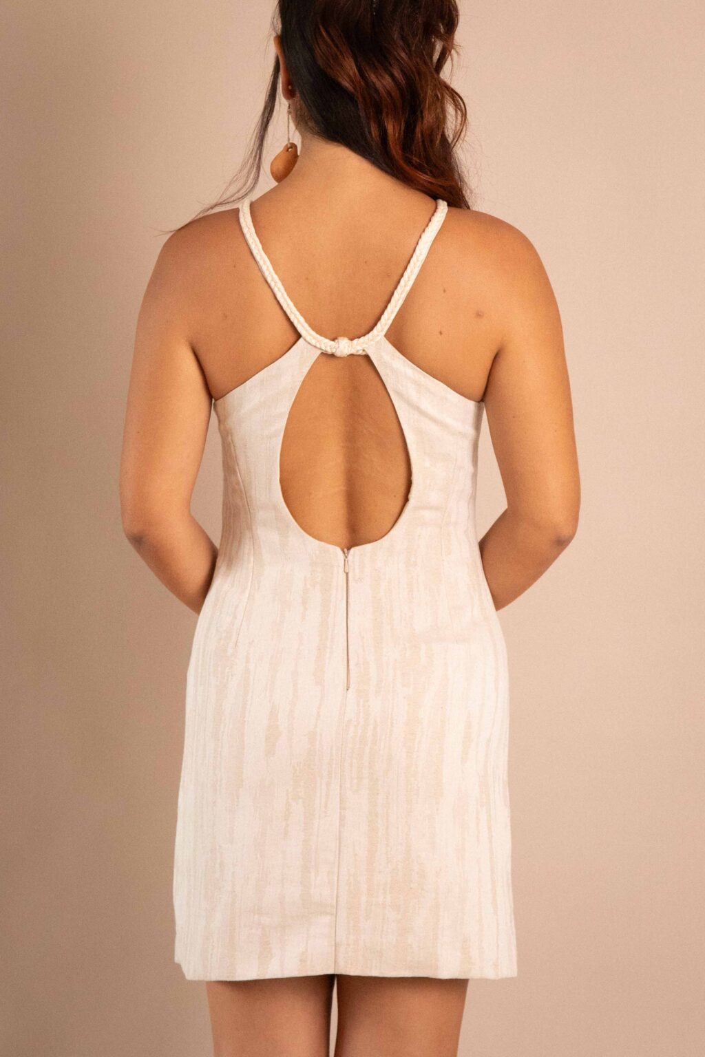 Vestido Creación de lino color natural con detalles trenzados frontales.