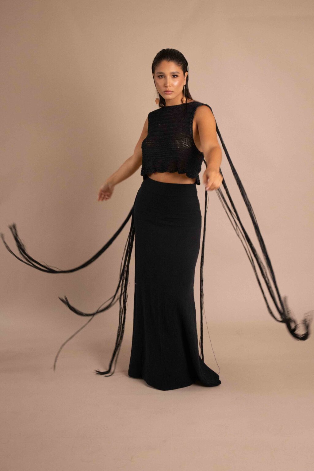 Top Iluminación negro tejido a mano, con flecos largos hasta el suelo y falda a juego.